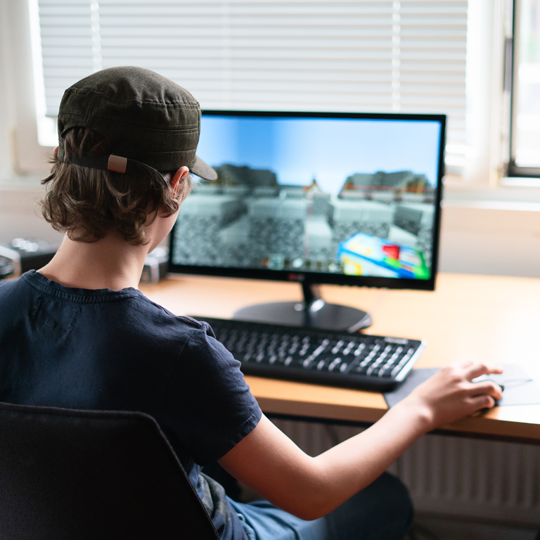 Ein Junge spielt Minecraft am Computer