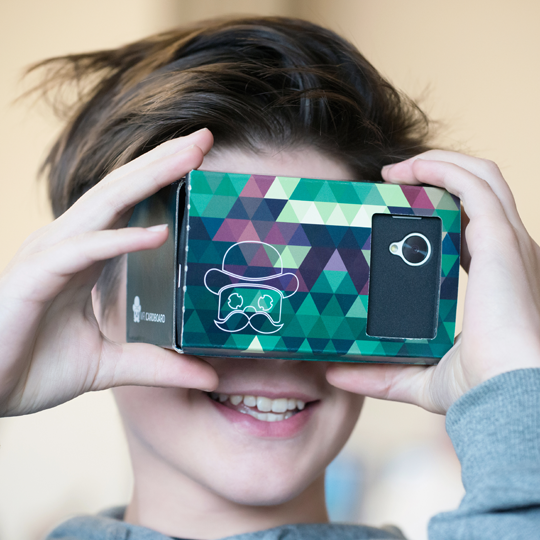 Ein Junge schaut durch eine Virtual Reality Brille und lacht