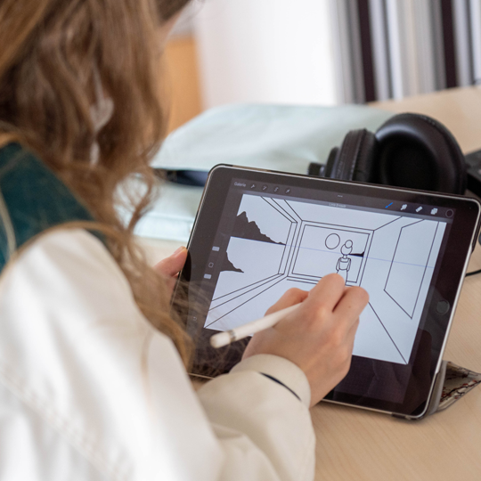 Ein Mädchen zeichnet auf einem Tablet mit digitalem Stift einen Raum