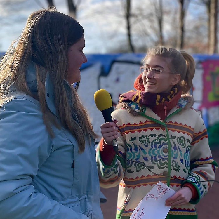 Ein Mädchen übt das Moderieren und befragt ein anderes Mädchen.