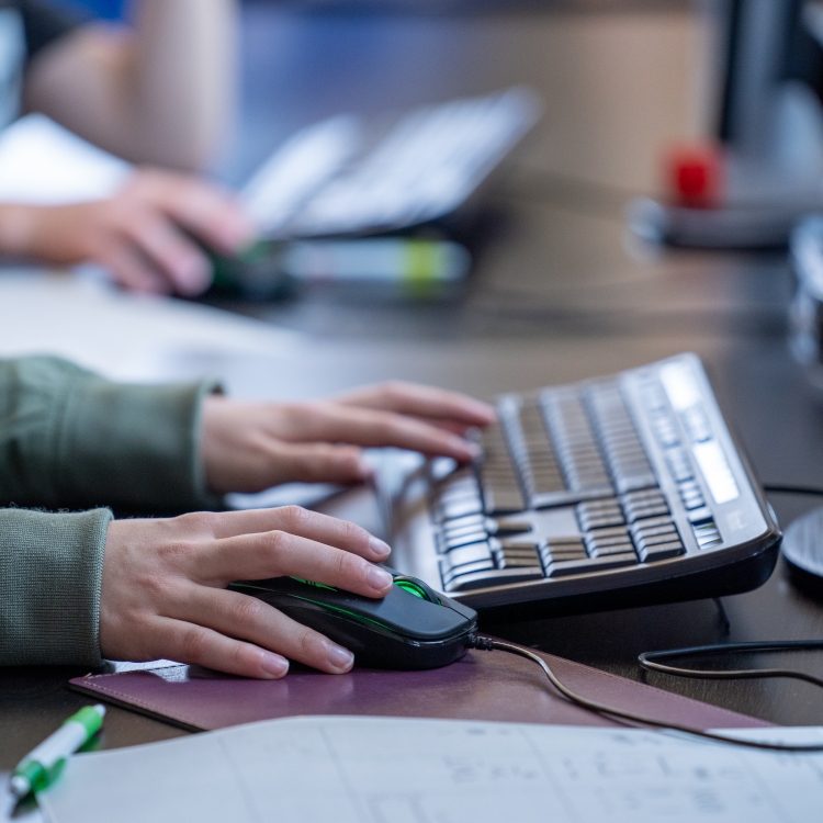 Hände auf Computertastatur und Maus