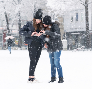 Zwei Mädchen bei einer Tablet-Rallye im Schnee.