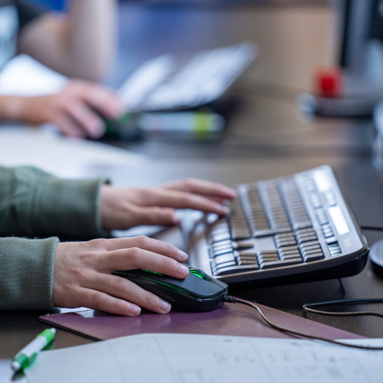 Kinderhände auf Computer-Tastatur und Maus
